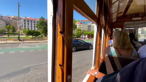 Turistas-Visitando-La-Arquitectura-De-Lisboa-A-Través-De-Las-Ventanas-Abiertas-Del-Recorrido-En-Tranvía-Antiguo-Durante-El-Día