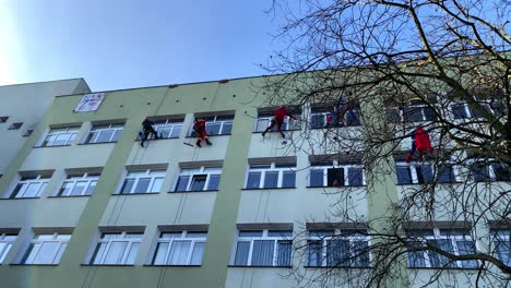 Escaladores-Benéficos-Para-Ventanas-Limpias-De-Wosp-En-Un-Hospital-Infantil-Con-Ropa-Divertida-En-La-Calle-Polanki-En-Gdansk,-Hospital-Maciej-Płażyński,-Montañeros-Trabajan-Socialmente