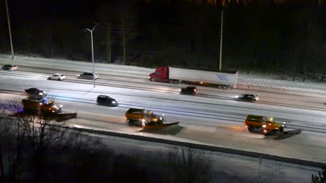 In-Einer-Kalten,-Verschneiten-Winternacht-Räumen-Aufgereihte-Schneepflüge-Den-Schnee-Auf-Der-Autobahn