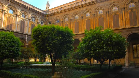 Toma-Panorámica-De-Un-Patio-Vacío-De-La-Galería-Doria-Pamphilj-En-Roma,-Italia-Con-árboles-De-Jardín-En-El-Centro-Del-Patio-Durante-El-Día