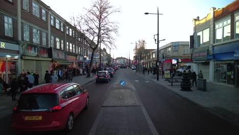 Blick-Auf-Den-Broadway-A4020-In-Southall-Mit-Vorbeiströmendem-Verkehr-Und-Menschen-Beim-Einkaufen-Am-Späten-Nachmittag-Des-16.-Januar-2022