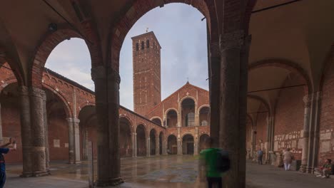 Lapso-De-Tiempo-Del-Edificio-De-Ladrillo-De-La-Iglesia-De-San-Ambrosio-Con-Campanarios,-Patio,-Arcos-En-El-Día-Lluvioso,-Milán,-Lombardía,-Italia