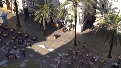 Mirando-Hacia-La-Típica-Plaza-Mediterránea-Con-Mesas-De-Café-Y-Palmeras