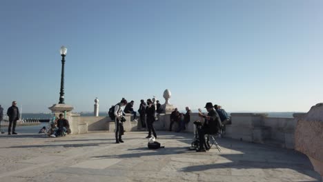 Músico-Actuando-En-Cais-Das-Colunas-Con-Turistas-Mirando