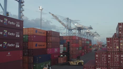 Forklift-Truck-Lifting-Cargo-Container-At-The-Husky-Terminal,-Tacoma-Port-In-Washington,-USA---drone-shot