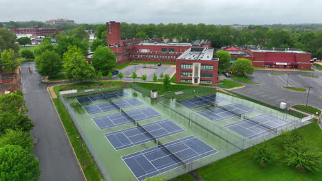 Rotación-Aérea-Alrededor-De-Las-Canchas-De-Tenis-En-Una-Gran-Escuela-Pública