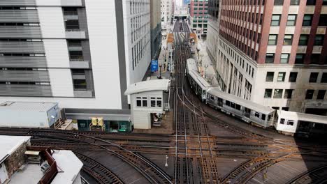 Vista-Aérea-De-Drones-Siguiendo-Un-Tren-En-La-Calle-Wells-En-El-Centro-De-Chicago,-Ee.uu.