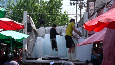 Mann-Entlädt-Riesige-Eisblöcke-Von-Einem-Lastwagen,-Die-Auf-Dem-Khlong-Toei-Markt-In-Bangkok-Verwendet-Werden-Sollen