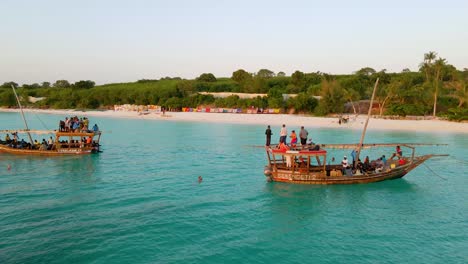 Nungwi-Beach,-Zanzibar---Tanzania---June-18,-2022---fishing-Boats-with-tourists-on-the-Indian-ocean-during-sunset