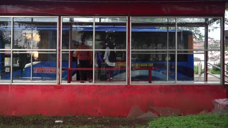 El-Autobús-Llegó-A-La-Estación-De-Autobuses-Y-El-Pasajero-Entró-Durante-El-Día-Soleado-En-La-Ciudad,-Toma-Amplia