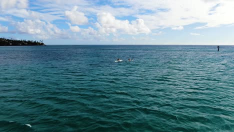 Toma-Aérea-De-Dos-Hombres-Remando-En-Canoas-A-La-Orilla-En-Hawaii