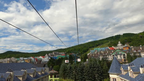 Vista-De-La-Cabina-Del-Teleférico,-Teleférico,-Teleférico,-Elevándose-Sobre-Hoteles-De-Montaña-En-El-Destino-Turístico-De-Mont-tremblant-Quebec,-Canadá,-Turismo-Y-Ocio-En-El-Tranvía-Aéreo