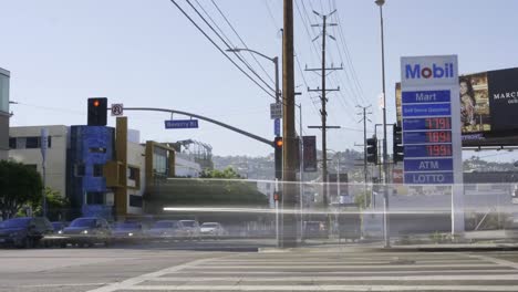 Timelapse-of-cars-driving-past-a-gas-station-in-Los-Angeles,-CA-with-the-most-expensive-gas-prices-in-America