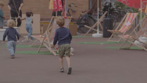 Niño-Joven-Que-Lleva-La-Pelota-De-Playa-En-Una-Plaza-Pública-En-La-Ciudad