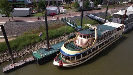 Luftaufnahme-Des-Touristischen-Schwimmenden-Pfannkuchenrestaurants-All-You-Can-Eat-Pannenkoekenschip-Vor-Anker-Am-Ufer-Der-Historischen-Hansestadt-Nimwegen,-Das-Auf-Passagiere-Im-Fluss-Maas-Wartet