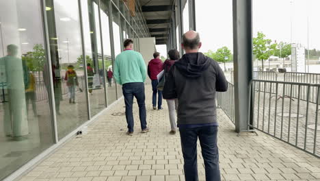 people-stand-in-line-in-front-of-entrance-of-vaccination-center