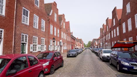 Walking-on-Cobblestone-Street-next-to-Red-Brick-Houses-in-Potsdam