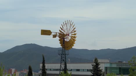 Yellow-Wind-Wheel-Spinning-Against-A-Bluish-Sky-In-Gallecs,-Mollet-Del-Vallés