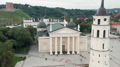 Antena:-Volando-Hacia-La-Catedral-De-Vilnius-Y-El-Campanario-Mientras-La-Gente-Camina-Por-El-Suelo-Durante-Las-Cálidas-Noches-De-Verano