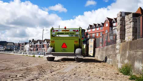 Consejo-De-Conwy-Surf-Rake-Playa-Ordenada-Máquina-Tirada-Detrás-Del-Tractor-En-El-Soleado-Paseo-Marítimo-De-Gales-Del-Norte