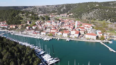 Yachthafen-Skradin-Mit-Luftaufnahme-über-Die-Stadt,-Hügel-Und-Wälder-Und-Den-Grünblauen-Fluss-Krka