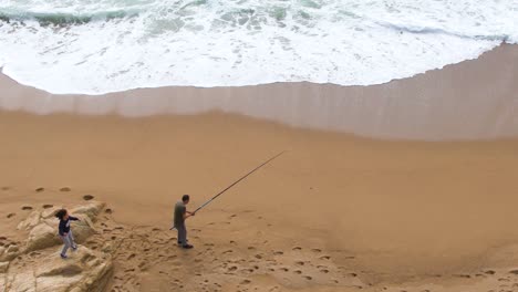 Draufsicht-Auf-Einen-Mann-Mit-Seiner-Tochter-Beim-Angeln-Am-Strand