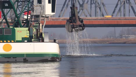 Grúa-Giratoria-En-La-Parte-Superior-De-Un-Barco-De-Dragado-Frente-A-Un-Puente-Que-Limpia-La-Vía-Fluvial-Del-Río-Ijssel-En-El-Ijsselkade