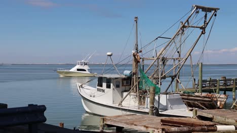 Cabin-Cruiser-Navegando-A-Través-De-La-Vía-Fluvial-Intercostera-Del-Golfo-Más-Allá-Del-Barco-De-Pesca-Comercial-Atracado