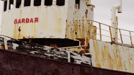 Gardar-De-Embarcación-Rústica-Abandonada-En-La-Costa-De-Islandia,-Bandeja-Rápida-A-La-Izquierda