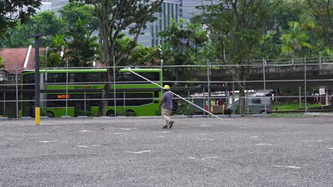 Construction-worker-walk-carrying-a-long--metal-bar