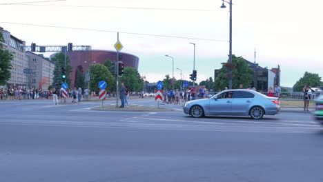 Inicio-Festivo-Del-Trofeo-De-Rally-Europeo-Fia-2021-Y-Desfile-De-Autos-En-Las-Calles-De-Liepaja,-Autos-De-Rally-Que-Pasan-A-Los-Espectadores,-Tiro-De-Seguimiento-De-ángulo-Medio