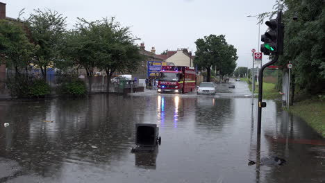 Ein-Londoner-Feuerwehrauto-Fährt-In-Tiefem-Hochwasser-An-Einem-Verlassenen-Auto-Vorbei,-Nachdem-Gewitter-Innerhalb-Weniger-Stunden-In-Der-Hauptstadt-Sintflutartige-Regenfälle-Im-Ausmaß-Von-Mehr-Als-Einem-Monat-Niedergegangen-Waren