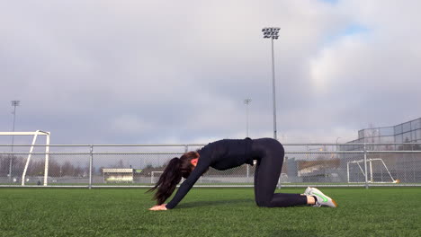 Chica-Flexible-Haciendo-Pose-De-Cobra-A-Pose-De-Niño-En-Césped-Artificial-En-El-Campo