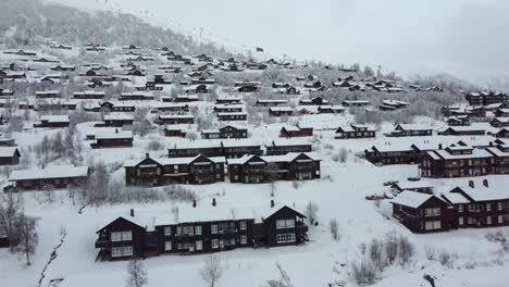 Temprano-En-La-Mañana-En-El-Pueblo-De-Montaña-De-Myrkdalen-Con-Telesquí-Corriendo-Hasta-La-Cima-De-La-Montaña-En-El-Fondo---Antena-Sobre-Casas-De-Ocio-Caras-Noruega