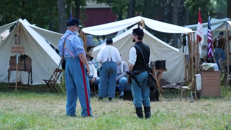 Älterer-Reenactor-Spricht-Mit-Jüngerem-Reenactor-In-Der-Nähe-Von-Zelten