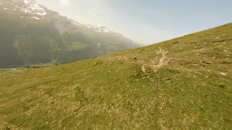 Atleta-Compitiendo-En-El-Sendero-Estrecho-Durante-La-Carrera-Raid-Evolènard-2021-Con-Vistas-Al-Valle-De-Val-D&#39;hérens-En-Suiza