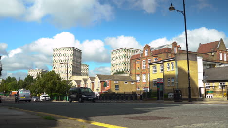 Cars-on-an-East-London-road-with-houses-and-council-estate-in-background