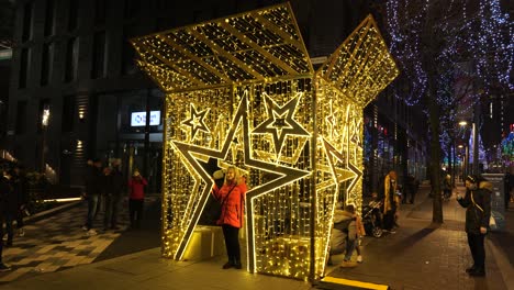 Female-Visitor-Poses-In-StarBox-For-Picture-Taking-At-Wembley-Park-In-London,-UK-At-Night