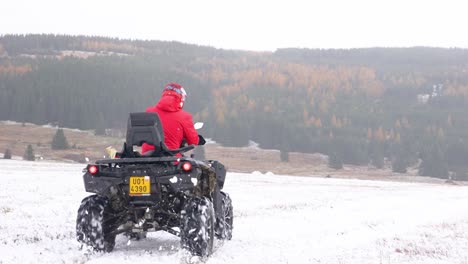 Die-Person,-Die-Ein-ATV-Schnell-Auf-Einem-Verschneiten-Feld-Fährt