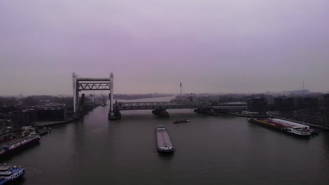 Vista-Aérea-Del-Puente-Ferroviario-Spoorbrug-Elevado-Sobre-Oude-Maas-En-Un-Día-Nublado-Con-Barcos-Pasando