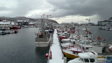 Drone-flight-over-quay-at-Skjervoy-harbor-with-many-fishing-boats-moored