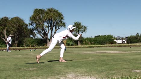 A-lady-delivers-a-wood-from-the-mat-during-lawn-bowls