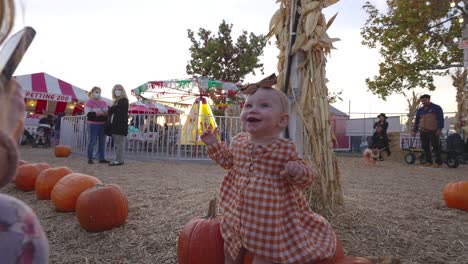 Niña-Feliz-Sentada-En-Una-Calabaza-Por-Primera-Vez-En-Pumpkin-Patch