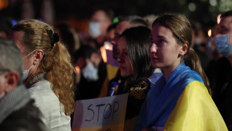 Joven-Ucraniana-Llorando-Durante-La-Vigilia-Por-La-Paz-Envuelta-En-La-Bandera-Ucraniana-En-Leiria,-Portugal