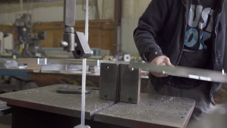 Trabajador-Metalúrgico-Quitando-Abrazaderas-Después-De-Cortar-Aluminio-En-Una-Sierra-De-Cinta