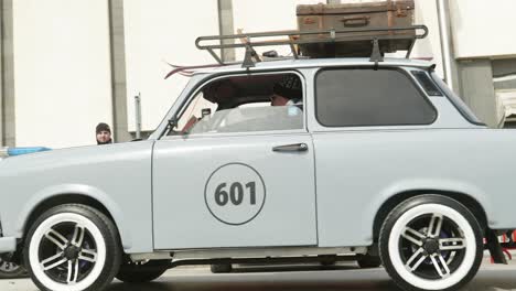 Konvoi-Osteuropäischer-Trabant-Retro-Oldtimer-Fährt-Durch-Die-Straßen-Der-Stadt,-Reist-Auf-Dem-Dachträger