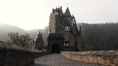 Die-Majestätische-Burg-Eltz-Mit-Einem-Atemberaubenden-Sonnenaufgangslicht,-Das-Das-Beeindruckende,-Alte-Gebäude-Beleuchtet