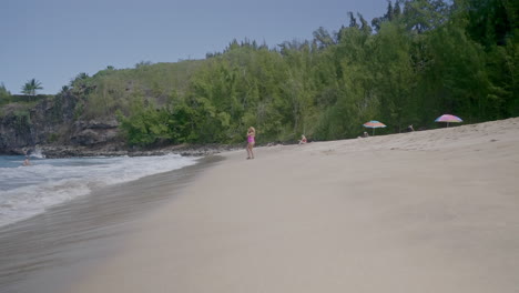 A-woman-walks-toward-the-ocean-while-on-vacation