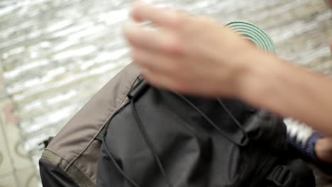 close-up-shot-of-hands-closing-a-backpack-and-picking-it-up-to-leave-on-a-trip