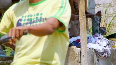 Women-crowd-around-the-public-water-access-point-to-do-their-laundry-by-hand